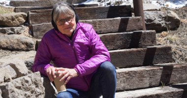 Kolay kıdemli giyen ceket ve etkilidirler ile içki ve kameraya bakarak devam