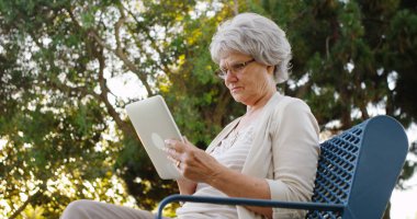 Üst düzey kadın parkta tablet kullanma