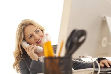 Bilgisayar başında ararken telefonda genç işkadını Close-up