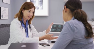 Genç latina hastaya tomografi kafatası, orta yaşlı Doktor ile gözden geçirme