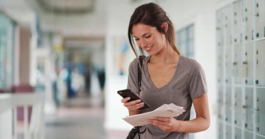 Bin yıllık beyaz kız mektup manifatura telefon üzerinde parsel dolapların tutarak.