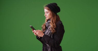 Yeşil ekranda Smartphone kullanan genç çekici kadın