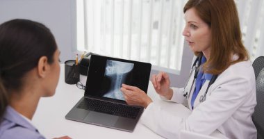 Orta yaşlı Doktor hastaların boyun içinde office x ışınları gözden sıkı atış