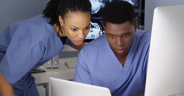 两名年轻医生在多台电脑上合作 — 图库照片