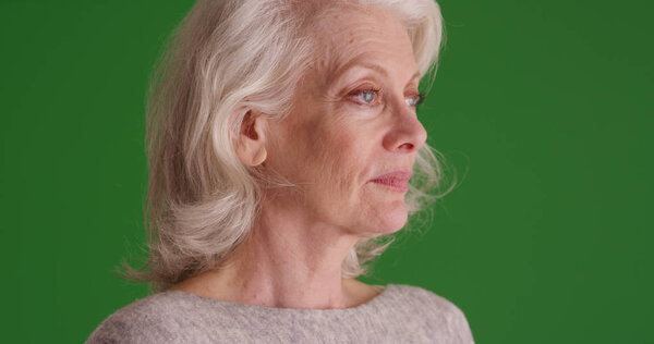 Old white lady deep in though looking off screen on green screen