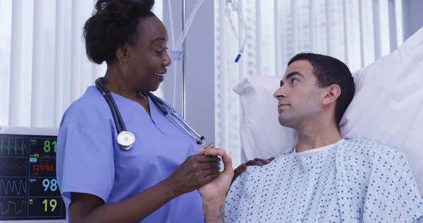 Portrait of black female nurse supporting young patient with positive attitude