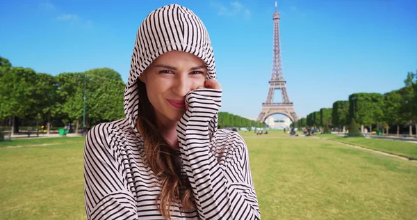 Happy Caucasian female smiling at camera in Paris near Eiffel Tower
