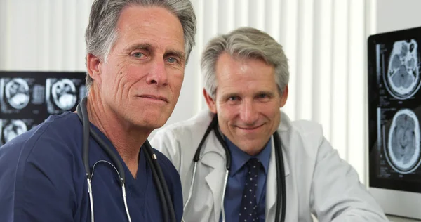 Mature Doctors Sitting Desk Smiling — Stock Photo, Image