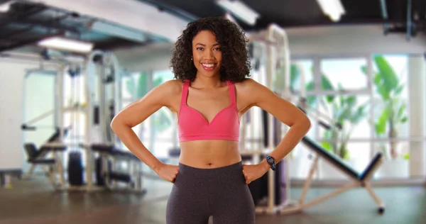 Happy healthy black young lady in sportswear posing and smiling for camera