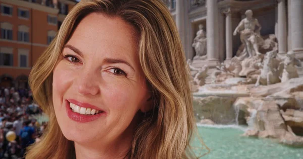 Caucasian woman at the Trevi Fountain laughing and smiling
