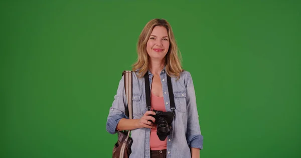微笑的中年白人妇女拿着数码相机在绿色屏幕上 — 图库照片