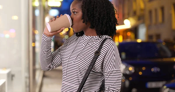 Niedlich Lächelnde Frau Trinkt Kaffee Und Schaut Abends Auf Schaufenster — Stockfoto