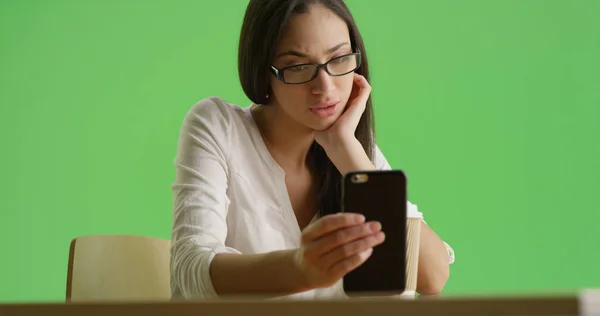 一个西班牙裔千禧一代在绿色屏幕上使用她的智能手机 — 图库照片