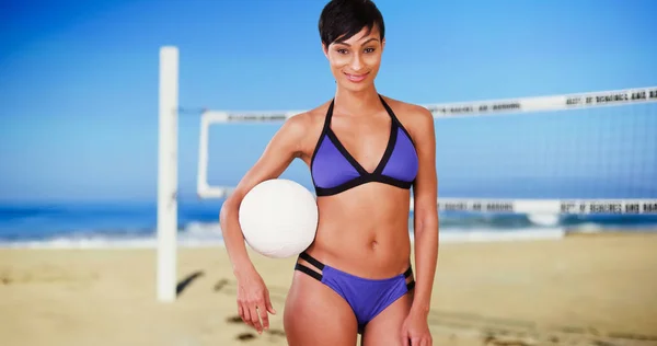 运动自信的黑人女子在网上海滩上打排球 — 图库照片