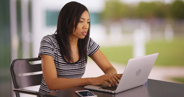 年轻的休闲非洲裔美国妇女独自在户外使用笔记本电脑 — 图库照片