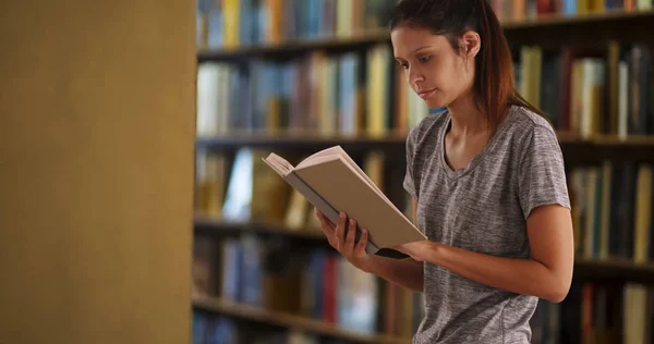 Beautiful Young Caucasian Woman Reading Library Stacks — Stock Photo, Image