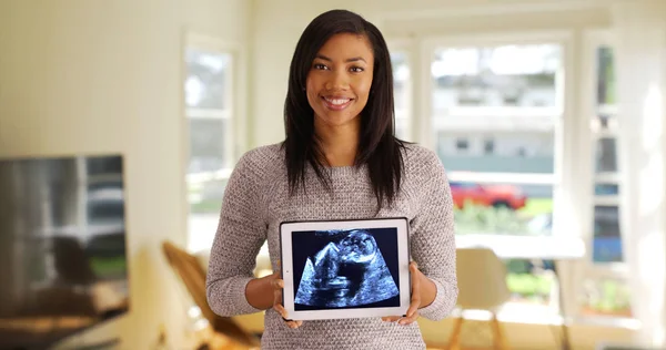 在平板电脑上显示超声波图像的快乐黑人女性的肖像 — 图库照片