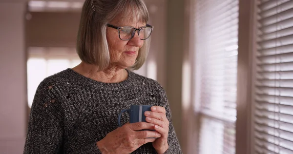 Somber Old White Woman Contemplating Holding Cup While Looking Out — Stock Photo, Image
