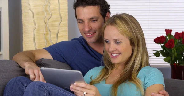 情侣在爱使用平板电脑在沙发上 — 图库照片