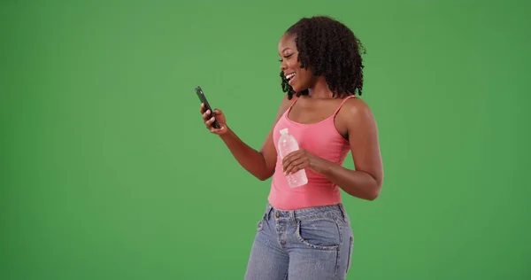 Mujer Negra Feliz Camiseta Rosa Con Botella Agua Usando Teléfono —  Fotos de Stock