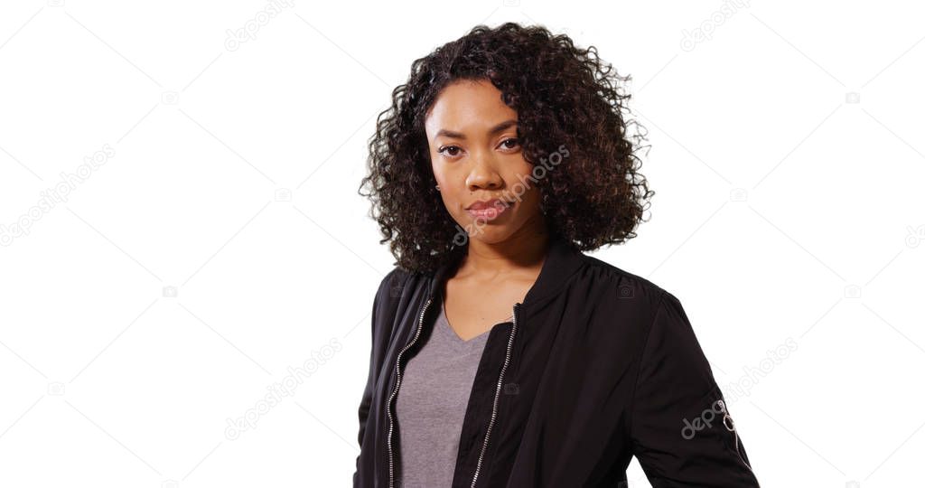 Confident African-American girl in her 20s posing casually on white background
