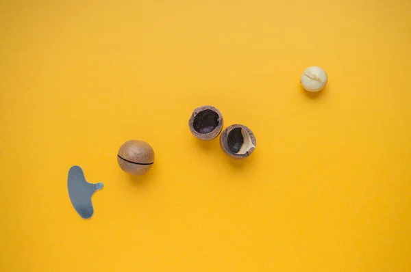 Tam ve açık Macadamia fındığı ve hardal arkaplanda anahtar. Macadamia cevizi çekirdeği. Macadamia cevizi için metal anahtar. Sarı arkaplan