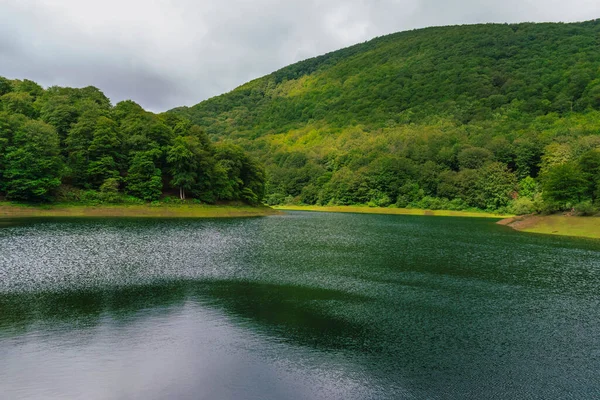 Güneşli ve bulutlu bir günde gölün yansıması.