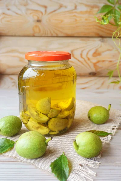 alkol dolu bir cam kavanozda yeşil ceviz, tedavi için tentür.