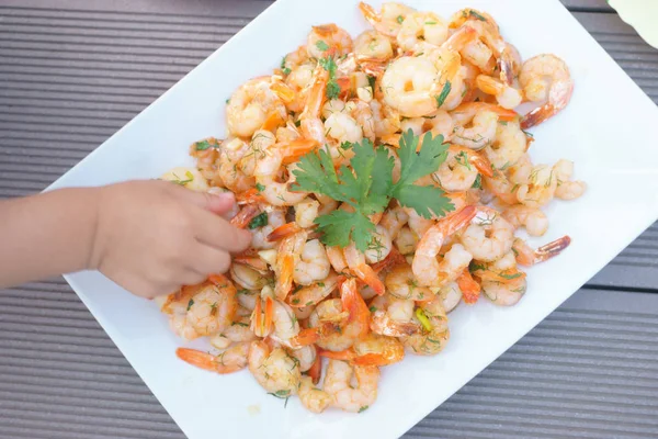 Camarones, manos de los niños toman camarones del plato — Foto de Stock