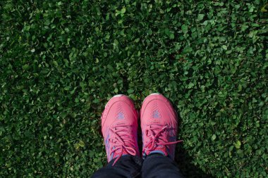 Bir bayan yeni ayakkabı giydikten sonra parkta koşmaya hazır.