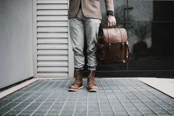 Elinde çok pahalı deri bir çanta tutan bir adam.