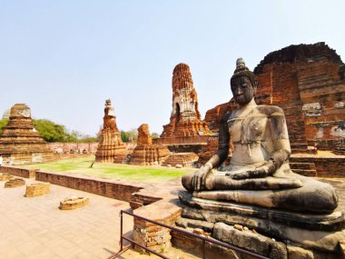 Önünde heykel ve mavi gökyüzü olan antik Ayutthaya tapınakları