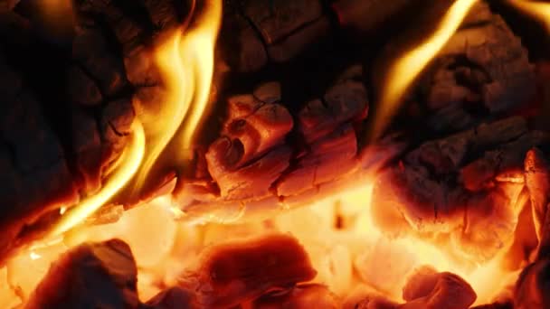 Огненные искры движутся в темноте на черном фоне, исходящем из ярко горящего тепла — стоковое видео