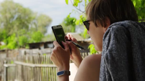 Frau nutzt Smartphone auf der Straße — Stockvideo