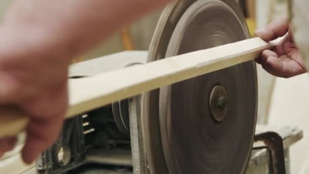 Anciano carpintero construye un pequeño barco con las manos de madera en un pequeño taller — Vídeo de stock