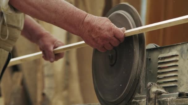 Пожилой плотник строит маленькую лодку руками из дерева в маленькой мастерской — стоковое видео