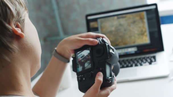 Fotógrafa feminina revisando fotos em sua câmera em casa — Vídeo de Stock