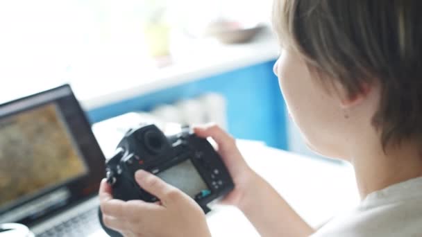 Fotógrafa revisando fotos en su cámara en casa — Vídeos de Stock