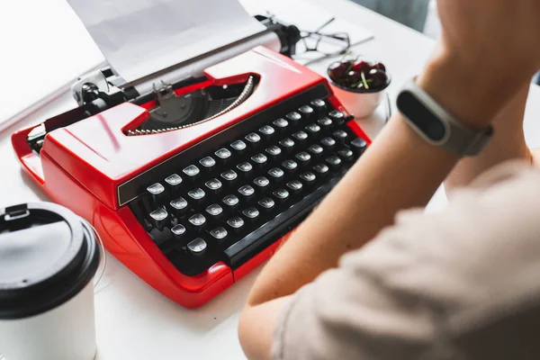 Femme écrivain réfléchie travaillant sur un livre sur sa machine à écrire bureau rouge — Photo