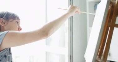 Kadın sanatçı ev Studio tuval üzerine resim çizer