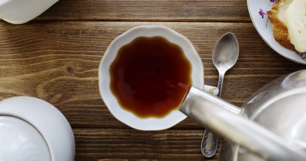 Tea from the kettle slowly pour into porcelain cup — Stock Video