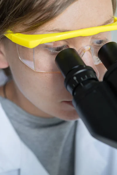 Scientist looking through a microscope — Stock Photo, Image