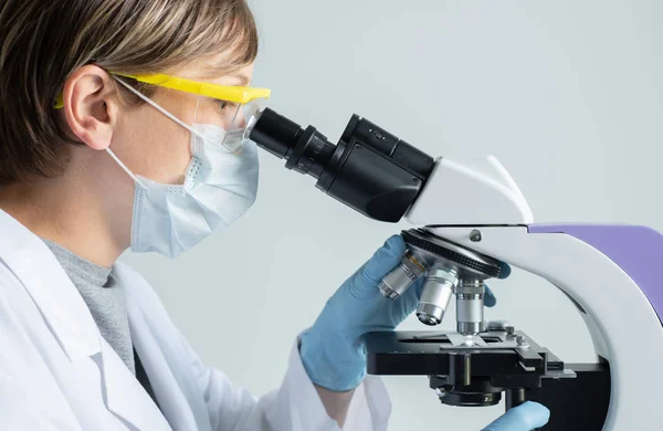 Scientist looking through a microscope — Stock Photo, Image