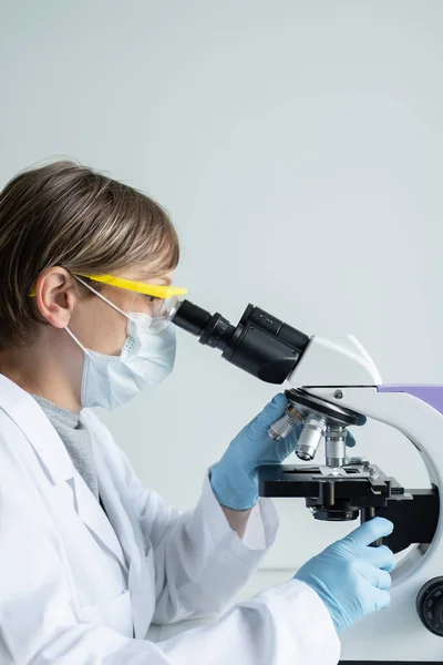 Scientist looking through a microscope — Stock Photo, Image