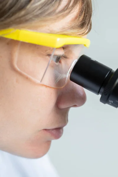 Scientist looking through a microscope — Stock Photo, Image