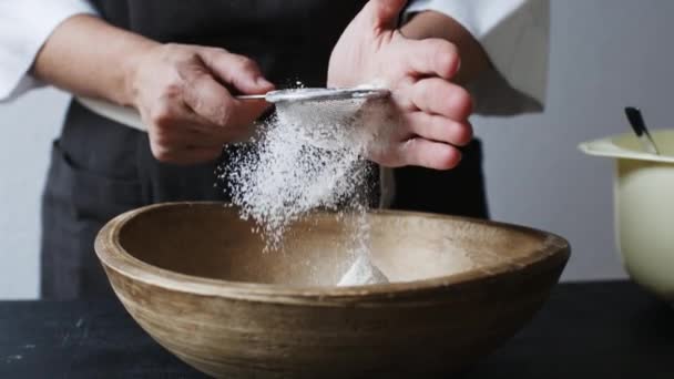 Mãos femininas peneirando farinha por tigela . — Vídeo de Stock
