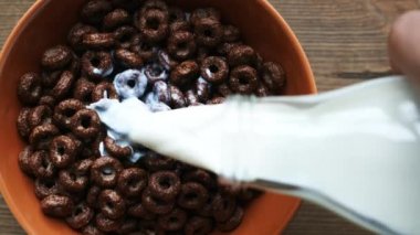 Süt şişe kase çikolata halkalar ile dökme yavaş görünümünü en iyi ürün