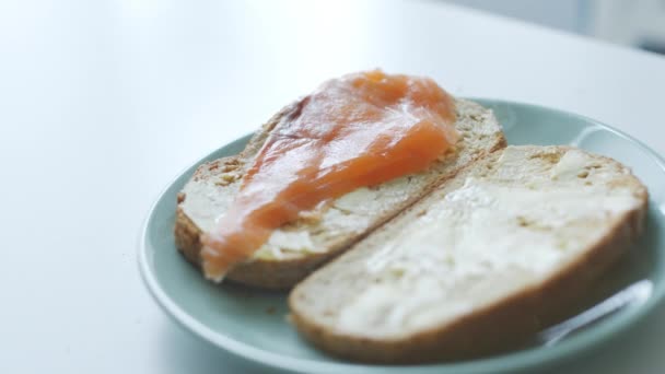 Woman makes simple fish sandwiches for breakfast — Stock Footage Woman makes simple fish sandwiches for breakfast Royalty Free Stock Video