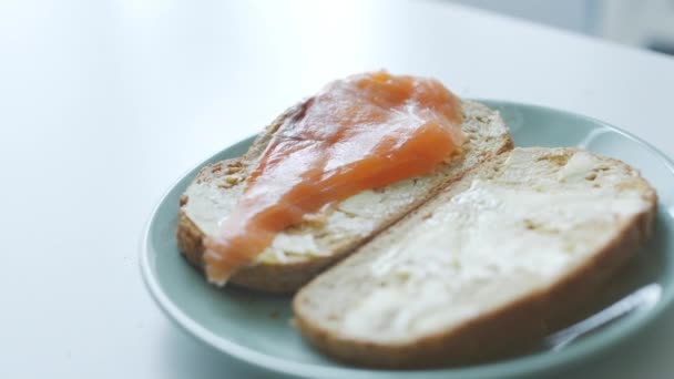 Mujer hace sándwiches de pescado simples para el desayuno — Vídeos de Stock