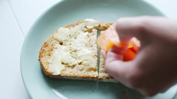 Mujer hace sándwiches de pescado simples para el desayuno — Vídeo de stock